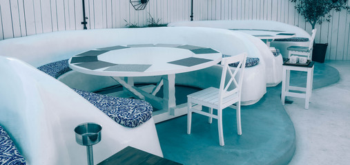 Beach restaurant interior. Cafe on the seaside, white wooden furniture, sunny.