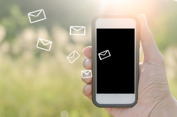 Copy space hand using smart phone and sun light in nature green park double exposure email draw background.