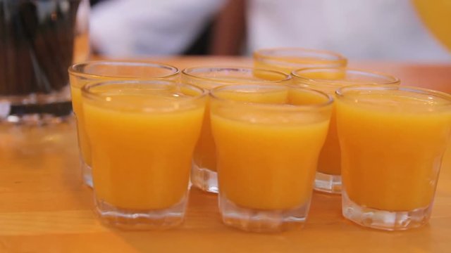 Many shot glasses with alcohol and citrus fruits juice