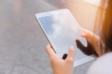 Copy space woman hand using smart phone and sun light on street background. Travel adventure lifestyle and business economic concept.