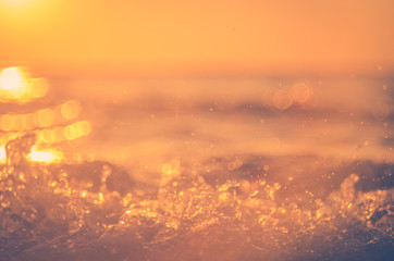 Blur tropical sunset beach with bokeh sun light wave abstract background.
