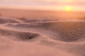 Blur tropical sunset beach with bokeh sun light sand abstract background.