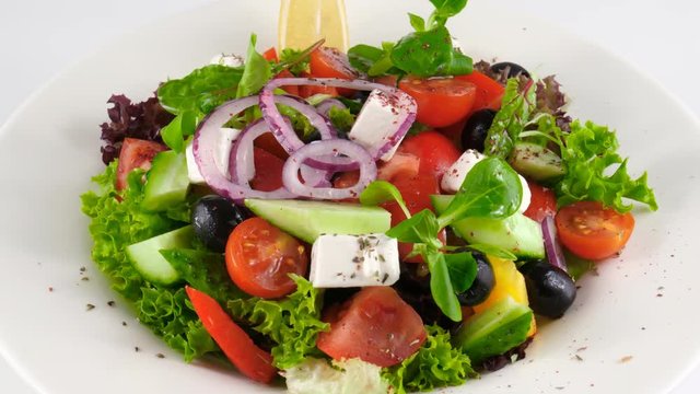 Restaurant Greek salad with feta cheese and tomatoes, olives, cucumbers, onion, red pepper, loop, 4K, ProRes codec, 422 HQ, ISO 100