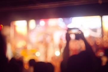 Fototapeta premium Blur people taking smart phone in night outdoor concert with colorful bokeh abstract background.