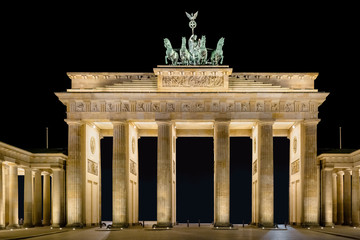 Obraz premium The Berlin Brandenburg Gate at night. The view falls from the east side to the gate. The figures of the Quadriga look east.