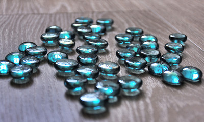 Blue decorative stones on wooden background.