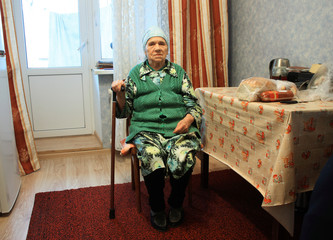 poverty old woman sitting on chair in the kitchen