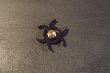 Famous fidget spinner stress relieving n a black wooden background