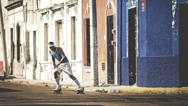 A man roller-skating in a street.