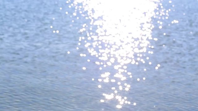 Sea tranquil surface and waves background. Beautiful blue water seascape with bright glitter of sunlight. Real time hd video footage.