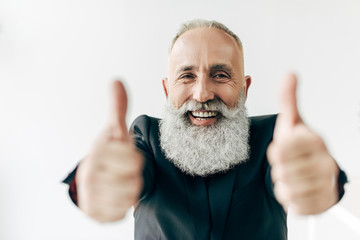 happy senior bearded businessman showing thumbs up