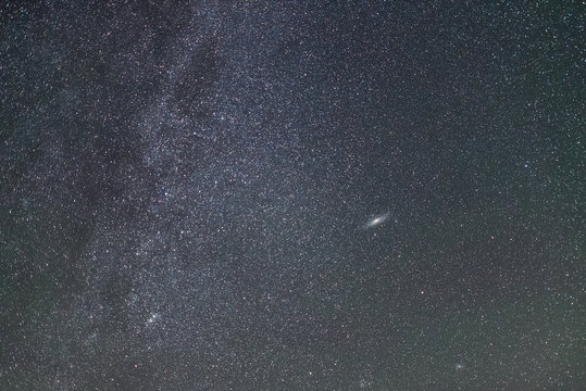 The center of our home galaxy and Andromeda galaxy, the Milky Way rising over the field