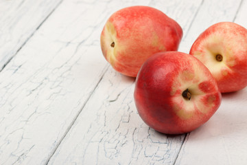 Ripe red peaches on the white wooden table