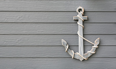 Close-up Wooden anchor with rope on wood plank wall background. © zilvergolf