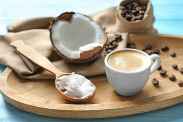 Tray with cup of tasty coconut coffee and nut on table