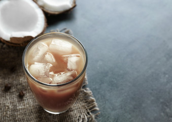 Glass of cold tasty coconut coffee on table