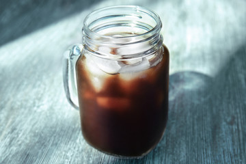 Mason jar with cold brew coffee on wooden table