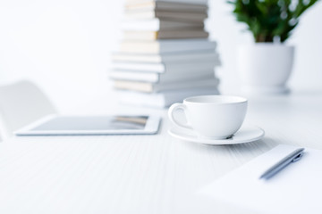 coffee and digital tablet on white desk, business composition
