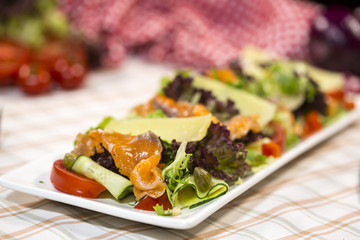 Salad with salmon, parmesan cheese, lettuce and rocket salad. Salad with fish.