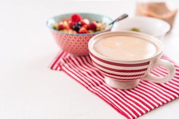 Healthy breakfast - cup of coffee, muesli and fresh berries on white wooden background, top view, health and diet concept