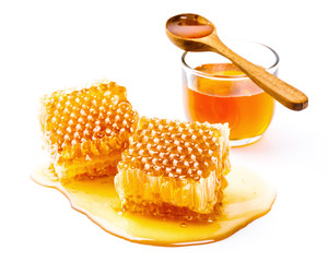 Honeycomb with jar and honey spoon isolated on white background