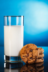 Milk in a jar and a glass and cookies on blue background