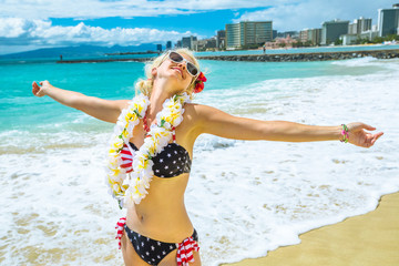 Happy female showing her her hawaiian lei necklace. Freedom woman with american flag bikini and...