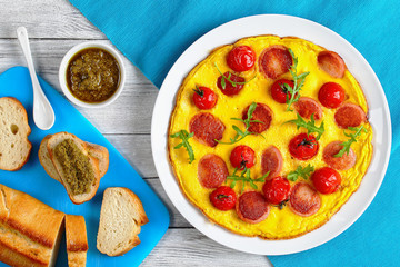 omelette with sausages, pesto sauce, toast