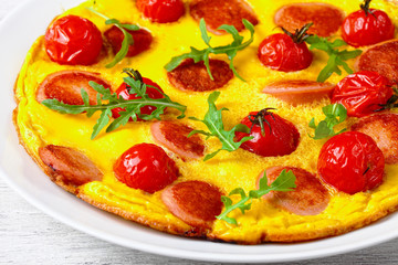 tasty omelette with sausages and tomato, close-up