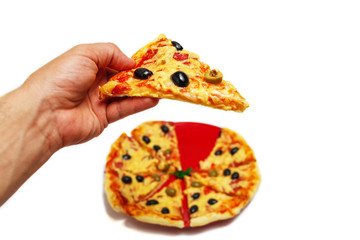 The man is holding a piece of pizza over his plate. Image on isolated white background.
