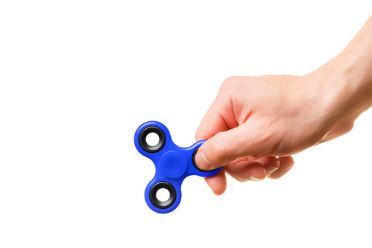 A man's hand holds a blue spinner on a white background
