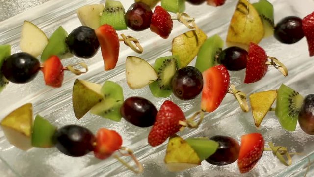 snacks with fruit on skewers lying on the glass table