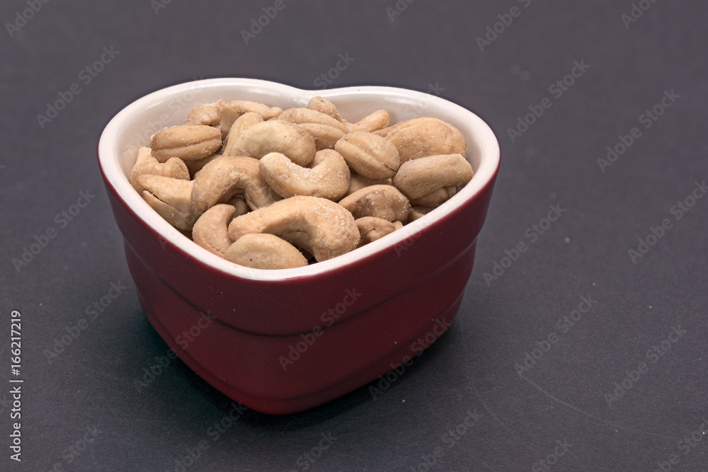 Wall mural Heart shaped bowl of cashew nuts