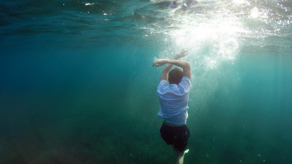 young man sinking into the sea