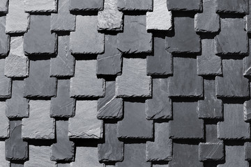 Overlapping stone slabs on a roof. Tiled shingles background