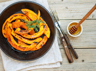 Baked slices of pumpkin with thyme and honey. Healthy dessert for gourmets. Selective focus