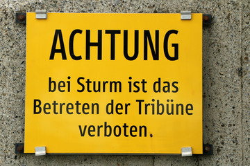 German Sign with "In the event of a storm, entering the grandstand is prohibited" , Schild an einer Zuschauertribüne
