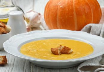 Homemade pumpkin cream soup with garlic croutons. A rustic style. Selective focus