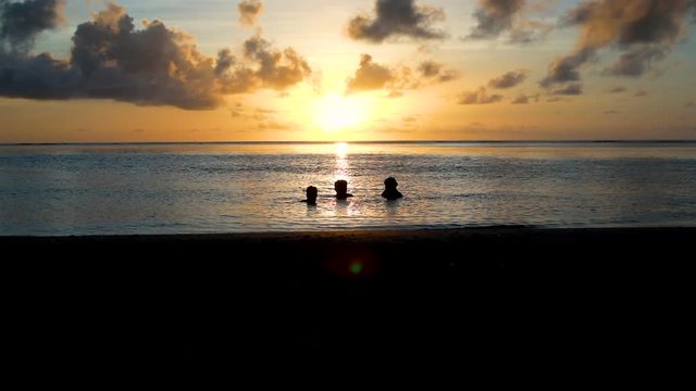 amis qui se baignent au coucher du soleil 