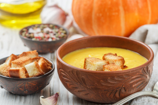 Homemade pumpkin cream soup with garlic croutons. A rustic style. Selective focus