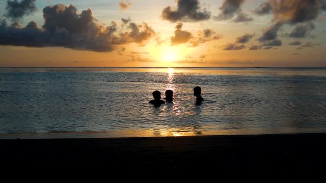 amis qui se baignent au coucher du soleil 