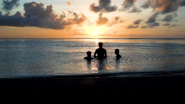 amis qui se baignent au coucher du soleil 