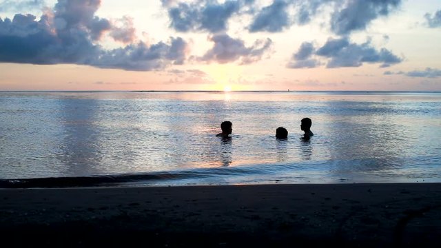 amis qui se baignent au coucher du soleil 