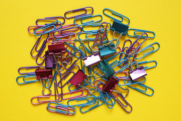 colorful paper clips on yellow background