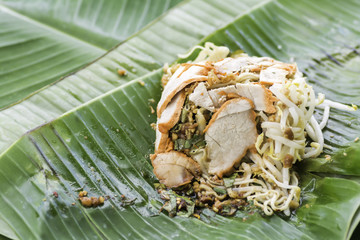 Pork dry noodles are placed on banana leaves.
