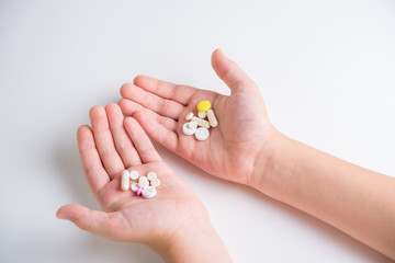 Fototapeta premium Tablets and pills in the hands of a close-up on a white background