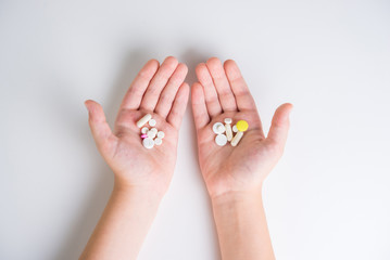 Tablets and pills in the hands of a close-up on a white background