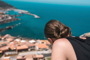 Fototapeta na wymiar Brunette woman looking over old italian town. Sardinia. Italy.