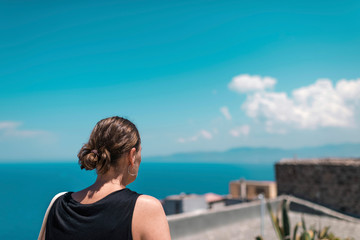 Fototapeta na wymiar Brunette woman enjoying ocean view from roof top. Sardinia. Italy.