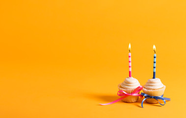 Cupcakes with candles celebration theme on a yellow background